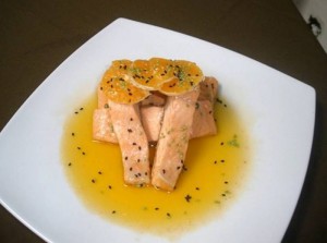 La trucha se tapa con la salsa y decora con las rodajas de mandarina.