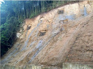 Perfilado del talud, instalación de drenes, anclajes y parrillas alrededor de los anclajes. Proceso constructivo.