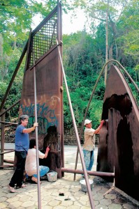 Dos personas trabajan en la restauración de la escultura de la Unab.