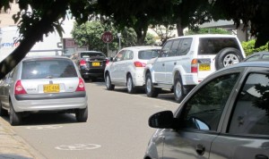 Se observan carros estacionados a lado y lado de la vía del barrio Las Mercedes